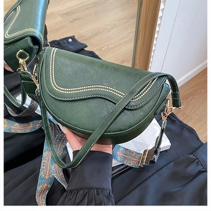 Détail du sac besace vert foncé en cuir avec bandoulière ethnique et points dorés