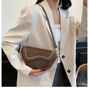 Gros plan d'un sac besace marron en similicuir avec bordure perlée blanche et fermoir doré