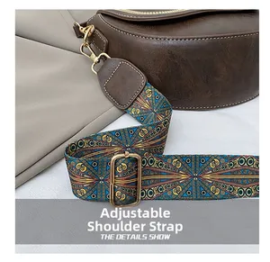Détail de la large bandoulière jacquard réglable avec boucle dorée sur sac en cuir brun