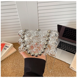 Detail of creative clear acrylic bubble handbag with silver beaded handle and chain strap