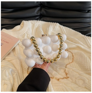 Detailed view of white bubble texture acrylic bag with gold bead handle and metal chain