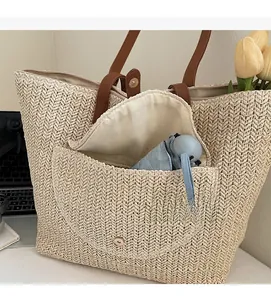Détail du sac en paille montrant une poche magnétique avant pour ranger un parapluie