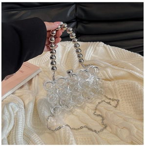 Detail of transparent bubble acrylic evening bag with silver metal ball handle and chain