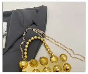Detail showing the gold beaded handle and studded metallic surface of the fashion box bag