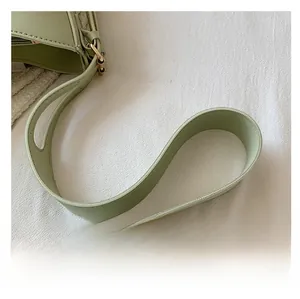 Detail of adjustable shoulder strap with fine stitching and gold-tone metal buckle