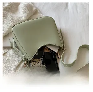 Top view of sage green crossbody bag interior showing spacious storage for makeup items