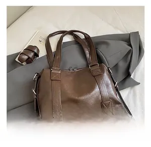 Detailed shot of dark brown oil wax leather tote bag with silver zippers and side straps