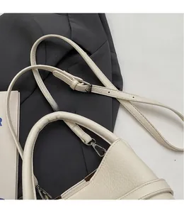 Détail du sac seau en cuir grainé blanc avec bandoulière réglable et boucle en argent