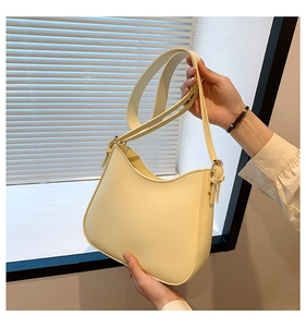 Detail of a light yellow hobo bag in smooth PU leather with adjustable shoulder strap