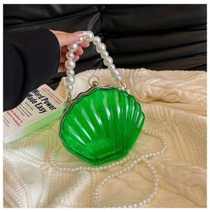 Detail of green acrylic shell evening bag with pearl handle and textured finish