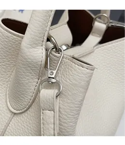 Gros plan détaillé du crochet en métal argenté et de l'anneau D sur sac en cuir blanc