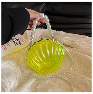 Close-up of yellow acrylic shell clutch with pearl handle and textured surface