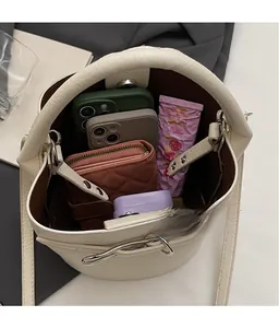 Vue de dessus montrant l'intérieur spacieux du sac seau blanc cassé avec des objets divers