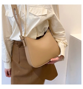 Detail of minimalist khaki PU leather shoulder bag with zipper and adjustable strap