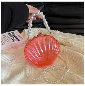 Detail of coral shell clutch featuring pearl handle and iridescent pearlized finish