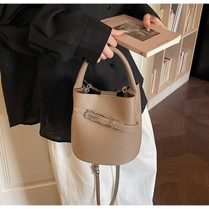 Détail du sac seau en cuir grainé kaki avec boucle métallique et texture lychee