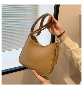 Close-up of a khaki leather hobo bag featuring fine stitching and a half-moon silhouette