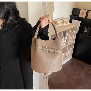 Détail du sac seau en cuir grainé kaki avec boucle argentée et poignée supérieure