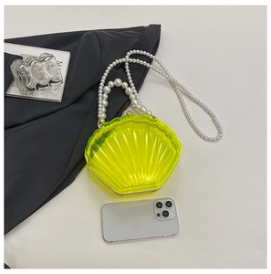 Detail of neon yellow shell acrylic evening bag with pearl handle and chain strap