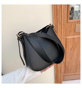 Detail of black PU leather shoulder bag featuring smooth texture and gold metal buckle