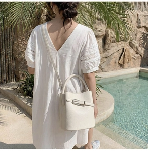 Détail d'un sac seau en cuir grainé blanc avec boucle élégante et texture de cuir riche