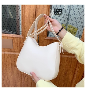 Minimalist white half-moon shoulder bag with adjustable strap and gold hardware