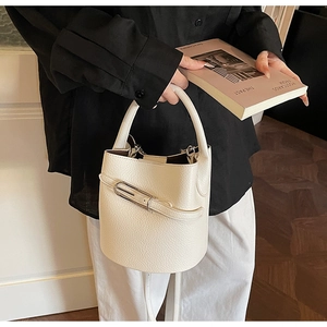 Détail du sac seau en cuir grainé blanc avec boucle argentée et poignée élégante