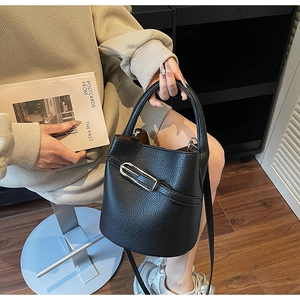 Détail du sac seau en cuir grainé noir avec boucle en métal argenté et poignée haute