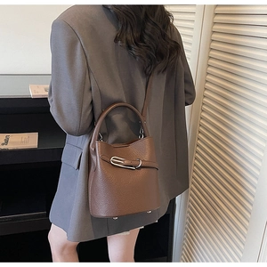 Vue détaillée du sac seau en cuir grainé marron avec boucle argentée et bandoulière