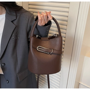 Détail du sac seau en cuir grainé café foncé avec boucle en métal argenté distinctive