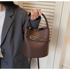 Détail du sac seau en cuir grainé marron foncé avec boucle argentée et sangle