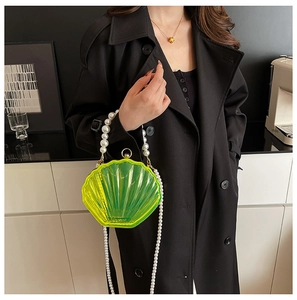 Close-up of neon gradient shell clutch featuring a large pearl handle and metal clasp