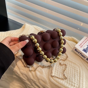 Chic dark chocolate bubble texture acrylic evening bag with gold bead chain strap on knitwear
