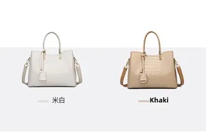 Detail of cream and khaki tote bags with crocodile embossing and metal charms