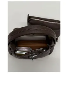 Deep brown lychee leather bucket bag showing spacious interior with zipper pouch