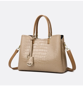Detailed macro view of beige crocodile embossed leather with gold ring hardware