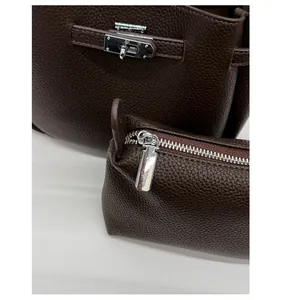 Close-up of dark brown lychee texture leather with silver twist lock and inner pouch