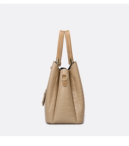 Side view of beige crocodile embossed handbag showing the D-ring and trapezoidal structure
