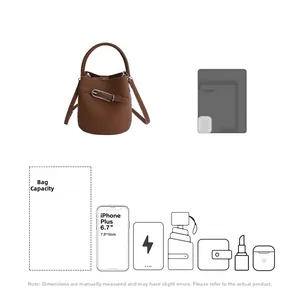 Détail du sac seau en cuir marron montrant sa capacité et sa taille par rapport au téléphone