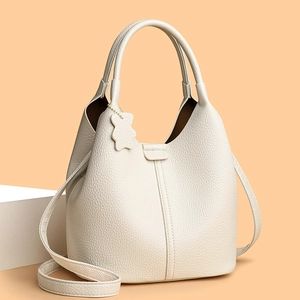 Minimalist cream white bucket bag with soft pebbled leather and cute bear charm pendant