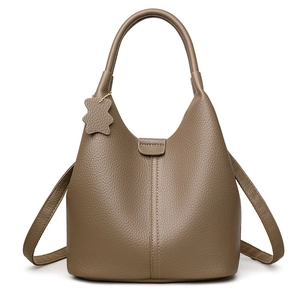 Dark brown leather bucket bag with litchi texture, dual handles and bear charm