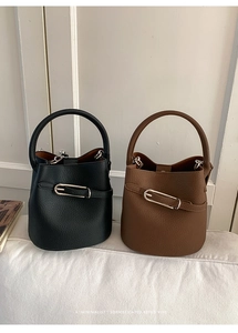 Gros plan sur des sacs seaux minimalistes noir et marron avec boucle en métal argenté