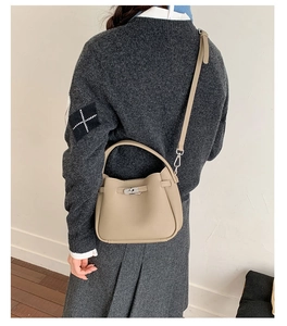 Sac seau kaki clair à motif litchi porté par un mannequin en jupe grise, vue arrière