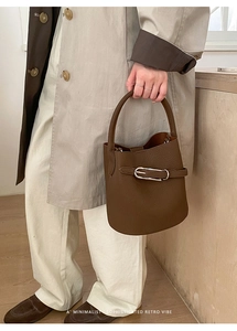 Gros plan sur un sac seau marron en cuir grainé avec boucle en métal argenté