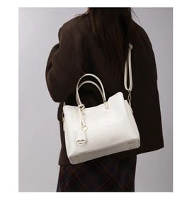 Detailed view of white crocodile pattern tote bag with gold zippers and detachable strap