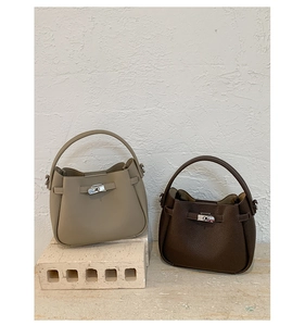 Vue détaillée des sacs seaux kaki et marron foncé en cuir avec texture grainée