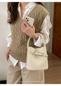 Détail du sac seau en cuir blanc avec boucle en métal argenté et sangle décorative