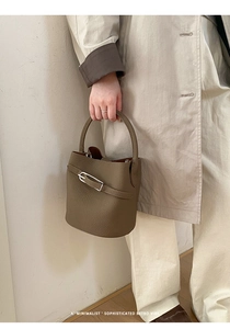 Vue détaillée du sac seau en cuir marron avec boucle argentée et poignée assortie