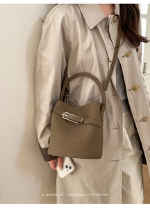 Gros plan du sac seau vert olive en cuir grainé avec des boucles en métal argenté