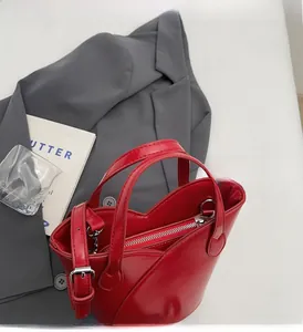 Detail of red leather bucket bag featuring unique heart-shaped top and silver hardware
